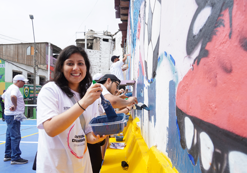 un grupo de chicos y chicas pintando mural en La Victoria, Lima - Perú